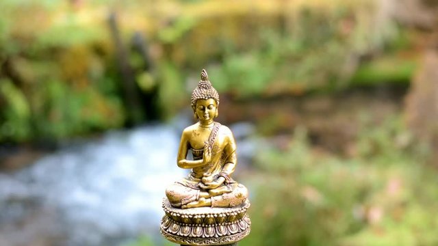 Segnender Buddha an einem kleinen Wiesenbach