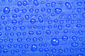 Abstract background of water droplets on blue surface.