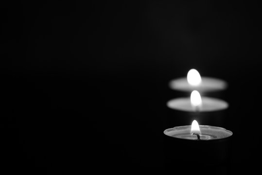 Burning candles in the dark. Black and white