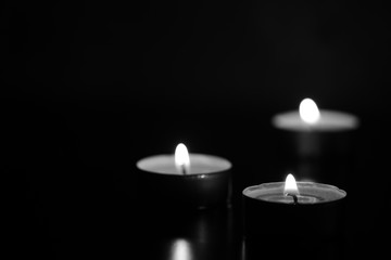 Burning candles in the dark. Black and white