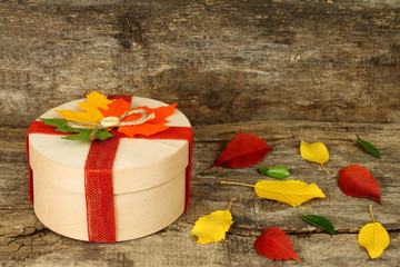 Autumn concept of present box with dried leaves