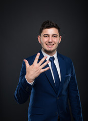Cheerful entrepreneur counting five fingers