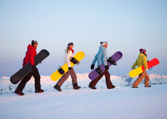 Group of snowboarders on top of the mountain.