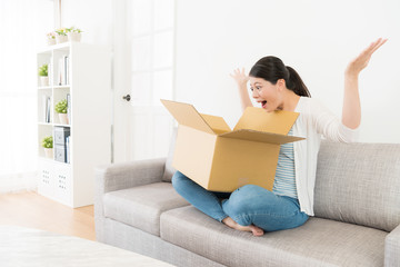 attractive girl sitting on sofa opening parcel box