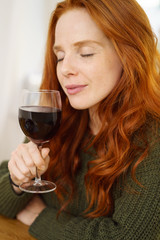 frau genießt ein glas rotwein mit geschlossenen augen