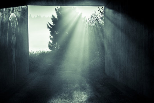 Sonne strahlt durch die Nebelschwaden am Ende eines Tunnels