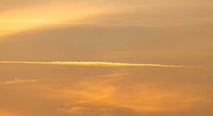 trail from the plane in the sky at sunset