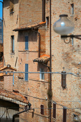 Fototapeta premium Urbino, Italy - August 9, 2017: architectural elements of a building in the old town of Urbino. Red brick and windows with shutters