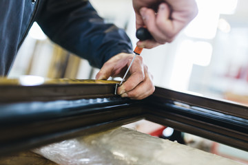 Manual worker cutting aluminum and PVC profiles. Manufacturing jobs. Selective focus. Factory for aluminum and PVC windows and doors production.