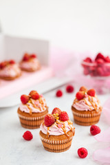 Raspberry and caramel cupcakes on white background