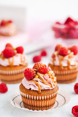 Raspberry and caramel cupcakes on white background