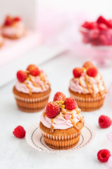 Raspberry and caramel cupcakes on white background