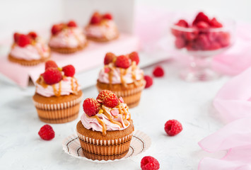 Raspberry and caramel cupcakes on white background