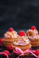 Raspberry and caramel cupcakes on dark background