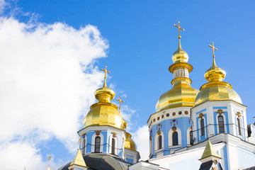 Fototapeta na wymiar Famous Saint Michael Golden Domed Monastery right photo. Yellow cupola of baroque church on blue sky background.