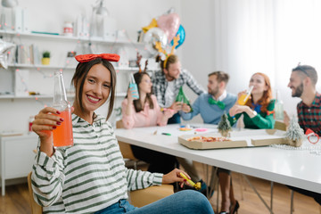 Sweet employee toasting at office party with colleagues in background