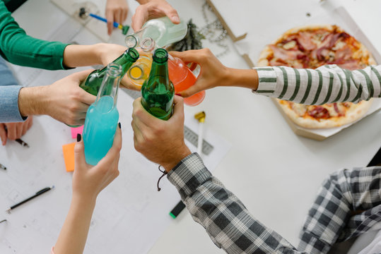 Coworkers toasting with various alcoholic drinks