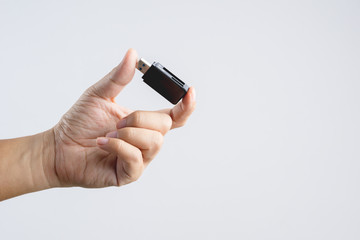 Fototapeta premium Hand holding black USB memory or storage card reader stick