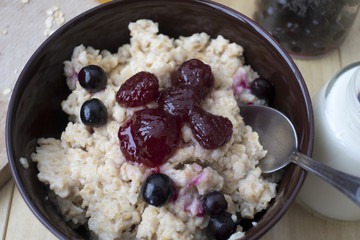 Delicious oatmeal porridge with berry and almonds for breakfast.