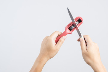 Hand holding knife blade sharpener, accessory for the kitchen