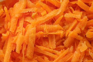 Grated fresh carrot macro shot, abstract texture