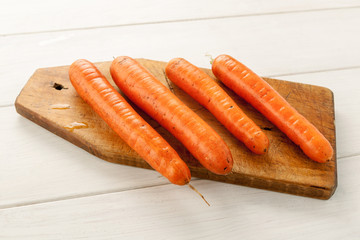 Fresh carrot on a wooden cutting board