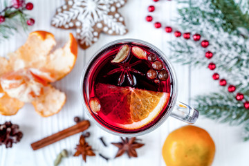 Christmas mulled wine with spices in cup on wooden background