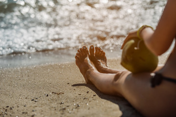 Girl with a coconut on the beach