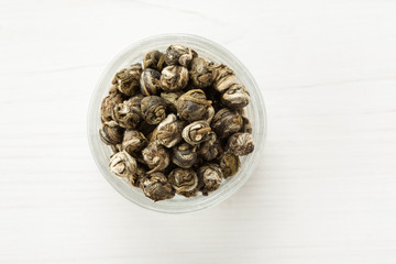 Dry tea balls in a small glass dish top view