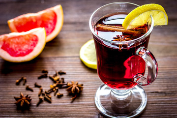 mulled wine with spices in cup on wooden background