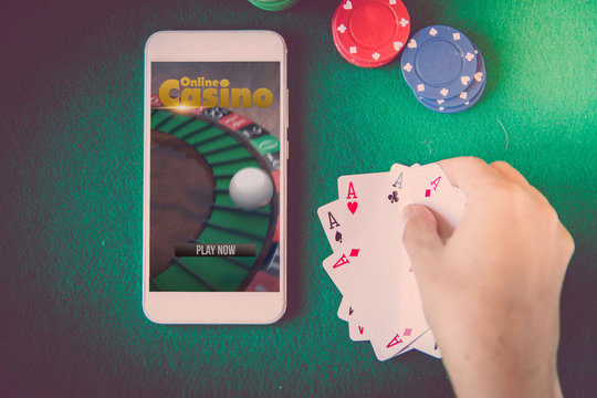 blank screen smartphone, chips and cards over poker table. Online casino concept.