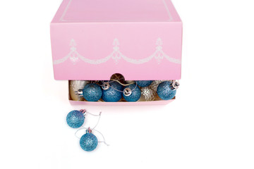 Blue balls on a Christmas tree in a pink box on a white background