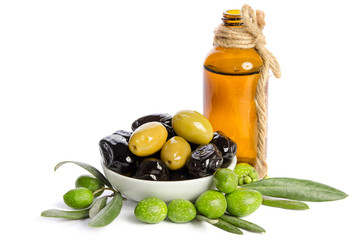 Black and green  olives  mixed in the  porcelain bowl and Virgin olive oil in a crystal bottle isolated on white background