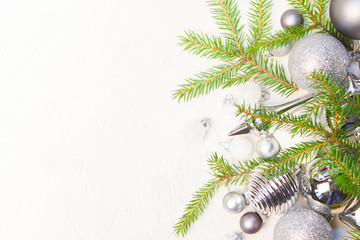 Christmas or New Year background: silver glass toys and balls, fir tree branches, decoration on...