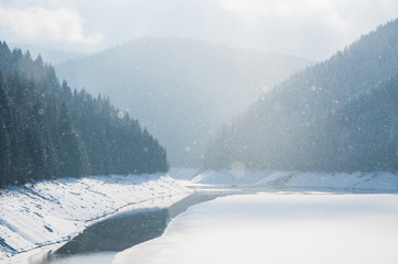 Frozen lake in the mountains, heavy snowfall