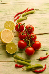 Lime, hot pepper, pears and tomato on wooden background