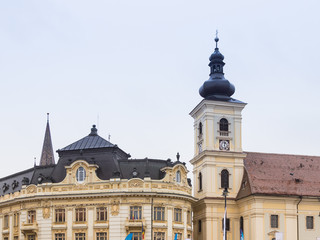Fototapeta na wymiar Fragment of the Roman Catholic Church of the Holy Trinity and Sibiu City Hall on the Large Square in Sibiu city in Romania