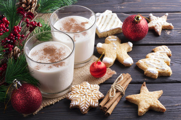 Glass of eggnog on wooden background