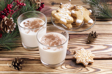 Glass of eggnog on wooden background