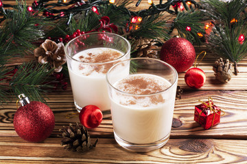 Glass of eggnog on wooden background