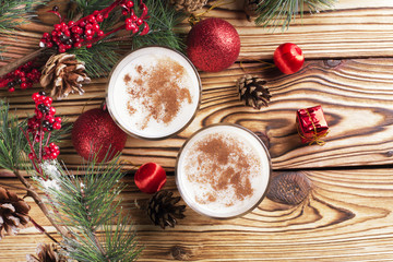 Glass of eggnog on wooden background