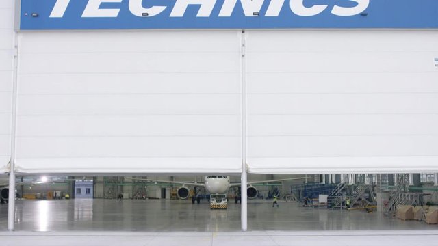 Aircraft in the technical hangar. Airplane parking in hangar. Airplane arrives at the hangar of the airport. Boeing