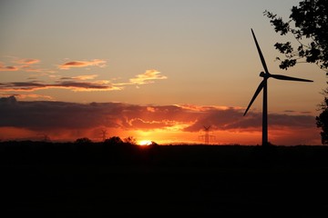 Obraz premium schöner farbiger sonnenuntergang mit windkraftanlage am abend