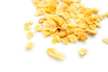 Macro of dehydrated garlic flakes isolated on white