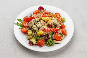 Closeup shot of a meet and vegetables salad on a white plate