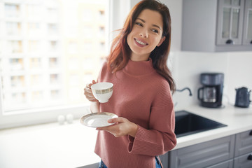 Woman with morning coffee in the kitchen - 180128426