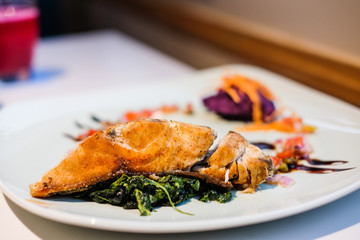 Deep fried mackerel steak with mashed purple sweet potatoes serve on white plate - organic food concept.