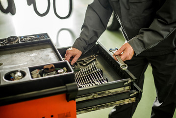 Mechanic taking facilities from special box for mechanical instruments.