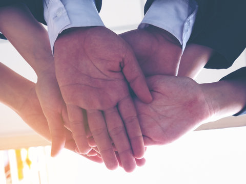 A group of business man and women stack hands together as a cooperate, business agreement successful