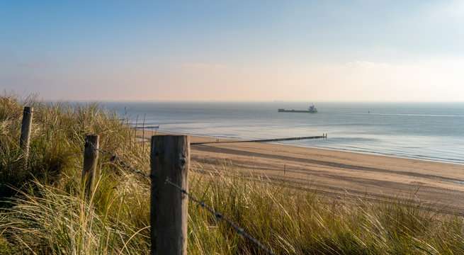 Beach with dunes at daytime. Beautiful dreamy shot of the endless sea in Zoutelande, Netherlands